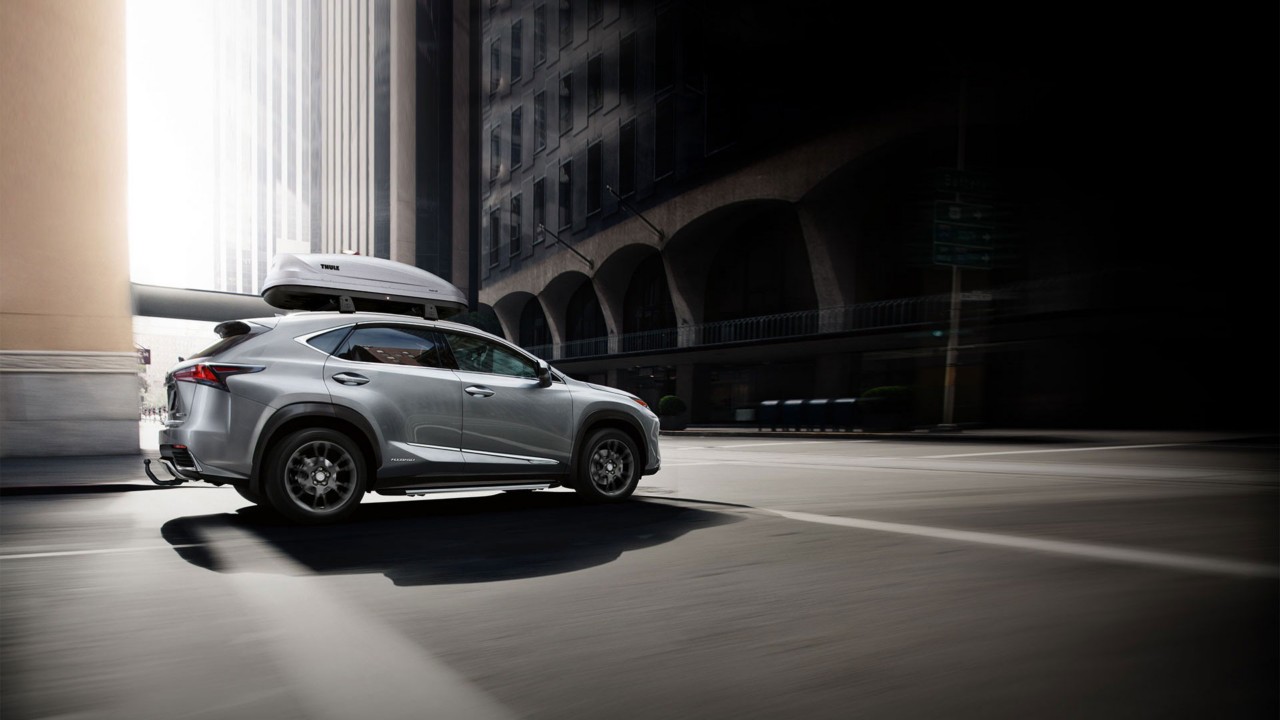 A Lexus RX with a roof rack driving through a city