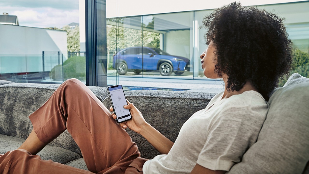 A woman using a mobile phone to access the Lexus Link app