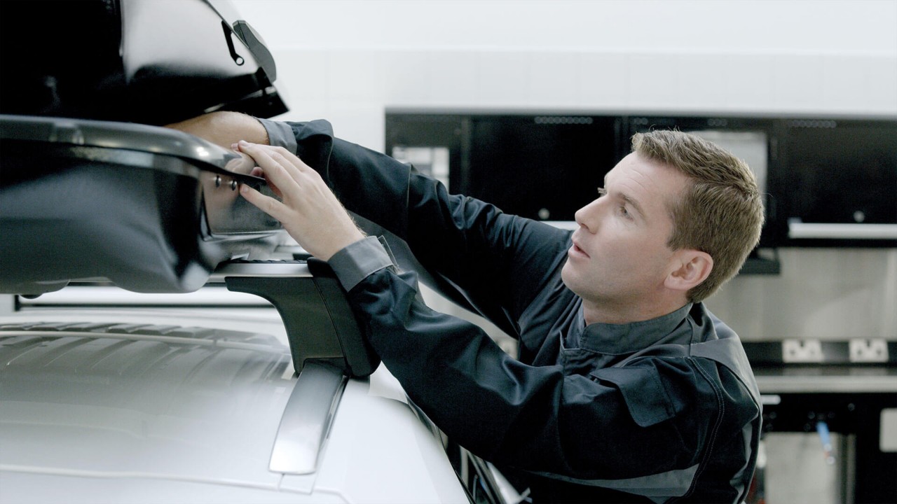 A Lexus mechanic fitting a roof box 