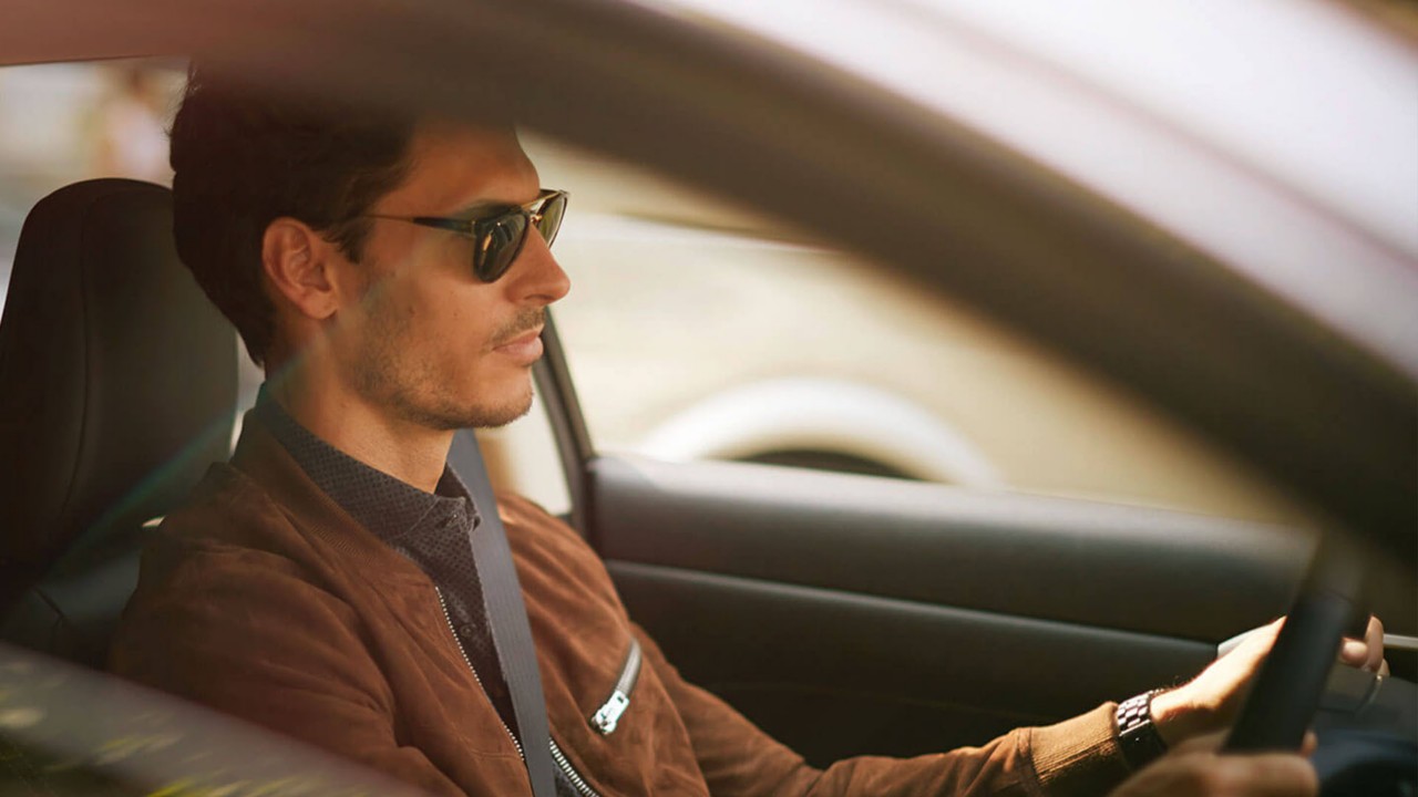 A person with their hand on a Lexus steering wheel