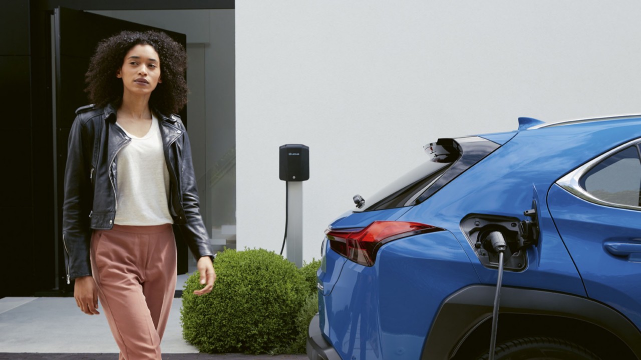 A woman next to a Lexus UX 300e