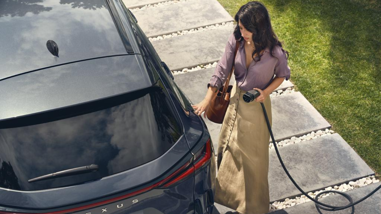 A person plugging in a charging socket into a Lexus NX
